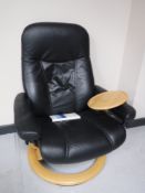 An Ekornes stressless black leather relaxer chair with tea tray