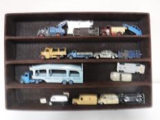A display case containing fourteen vintage die cast vehicles, Dinky, Corgi,