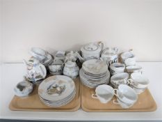 Two trays of two Japanese tea services one with an image of a Geisha