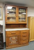 An early twentieth century and later oak kitchen cabinet with advertising decoration 'Tunstall &