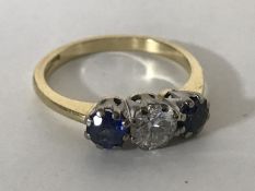 An 18ct gold three stone sapphire and diamond ring, the central stone weighing approximately 0.