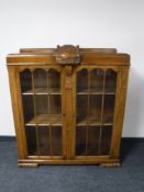A carved oak glazed door double door bookcase