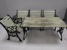A wrought iron garden table with wooden slats,