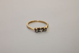 An 18ct gold three stone diamond ring, size M.