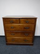 A walnut five drawer chest with brass drop handles