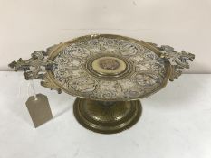 A late nineteenth century silvered brass comport stand with central coin , width 32 cm.