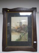 A colour print depicting a windmill in an oak arts and crafts style frame