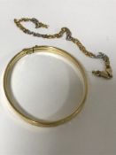 A 14ct gold bangle, together with two-tone chain of the same fineness.
