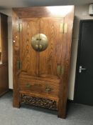 A Chinese style hardwood cabinet fitted with a drawer