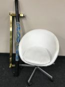 A brass fire curb together with a white vinyl chair and a didgeridoo