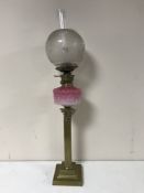 A Victorian oil lamp with pink glass bowl