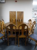 An early twentieth century oak extending dining table with four leaves and ten chairs