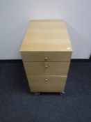 A light oak three drawer filing cabinet