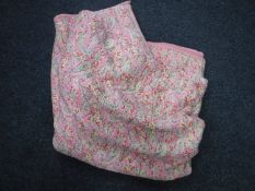 An antique pink floral quilt