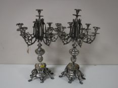 A pair of white metal candelabrum on stands