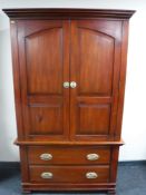 A stained pine double door cabinet with drawers beneath