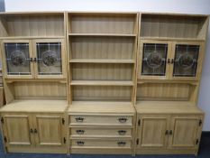 A three part oak bookcase with cabinets and drawers below
