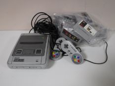 A Super Nintendo with two controllers and fifteen games