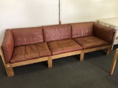 An oak framed mid 20th century three seater settee with Burgundy leather cushions
