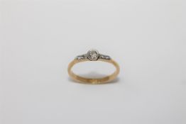 An 18ct gold diamond ring, the central stone approximately 0.2ct, size N/O, 2.3g.