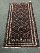 A Tekke design rug on mauve ground, 180 cm x 94 cm.