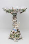 A continental porcelain tazza decorated with cherubs, height 34cm.