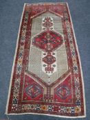 A North-West Persian village rug, 244cm by 109cm.