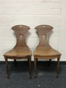 A pair of 19th century mahogany hall chairs with crested backrests, width 46cm.