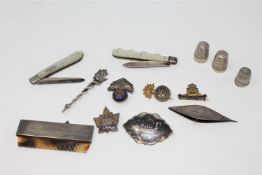 A collection of silver and white metal items including thimbles, combe, military badges, pen knives,