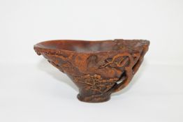 A Chinese carved rhinoceros horn libation cup, late Qing period, of warm-toffee tone,