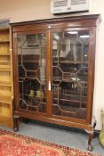 A late Victorian astral glazed mahogany display cabinet, on claw and ball feet, width 134cm.