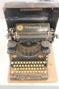 An early 20th century Monarch Visible typewriter in tin case.