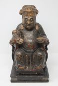 A Chinese lacquered and parcel gilt figure of a seated deity holding a ruyi sceptre, Qianlong,