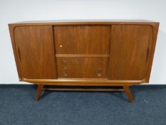 A mid 20th century teak sliding door cabinet, width 200cm.