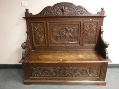 A 19th century carved oak settle, width 152cm.