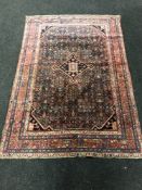 A Persian rug, on pink and indigo ground, 201cm by 136cm.