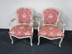 A pair of continental gilded white salon chairs, width 57cm.