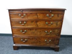 A George III mahogany chest of four drawers, with brushing slide, raised on bracket feet,
