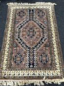 A Caucasian design rug, on peach ground, 192cm by 126cm.