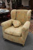 A Victorian style wingback armchair upholstered in a floral fabric, width 92cm.