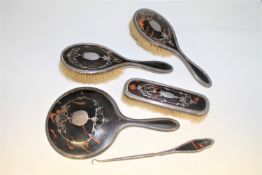 A silver and tortoise shell five piece dressing table set.