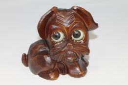 A novelty German carved timepiece in the form of a dog, with revolving eyes to indicate the time,