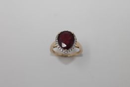A 9ct gold heart shaped ruby ring, the central stone surrounded by a halo of diamonds, size N, 4.4g.