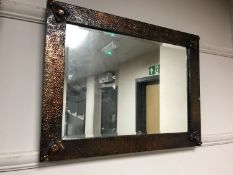 An Arts and Crafts copper framed mirror, width 59 cm.