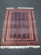 A fringed Bokhara design rug, on blue ground, 167cm by 126cm.