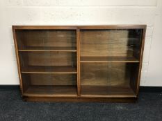 A mid 20th century oak sliding glazed door bookcase, width 138cm.
