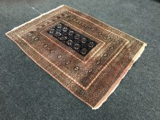 An Afghan Tekke design rug, on brown ground, 178cm by 130cm.