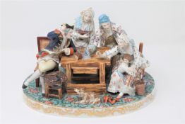 A continental porcelain figure group depicting figures revelling at a table,