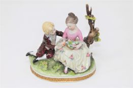 A Capodimonte porcelain figure of a girl and boy seated on a tree branch, height 13cm.