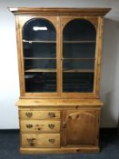 A 19th century pine glazed bookcase fitted with three drawers and a cupboard below, width 131cm.